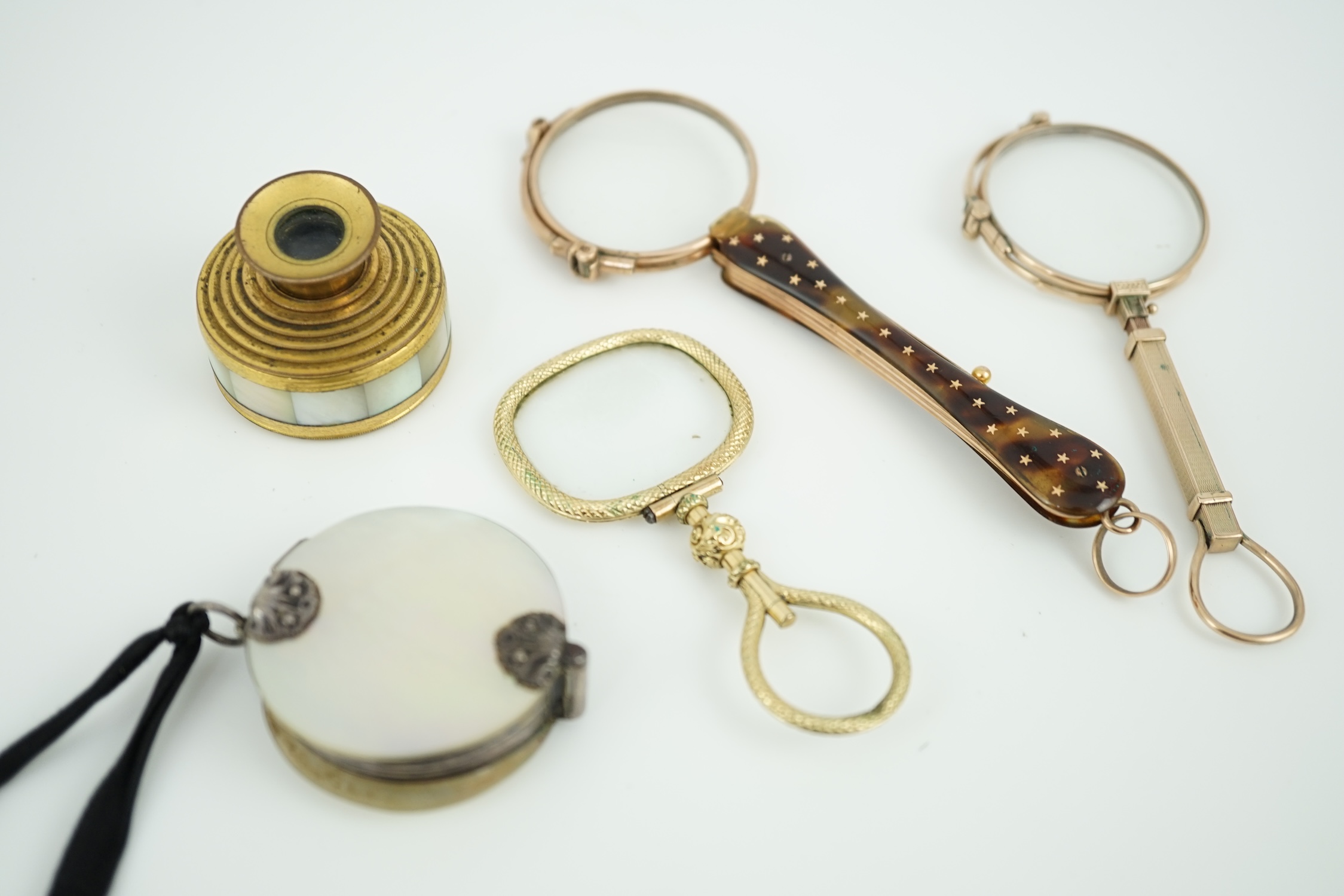 A 19th century mother of pearl and white metal mounted folding double magnifying glass, 40mm, two yellow metal mounted lorgnettes including Hamblin, London, a spy glass and a mother of pearl mounted gilt metal monocular.